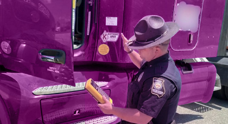 officer inspecting semi